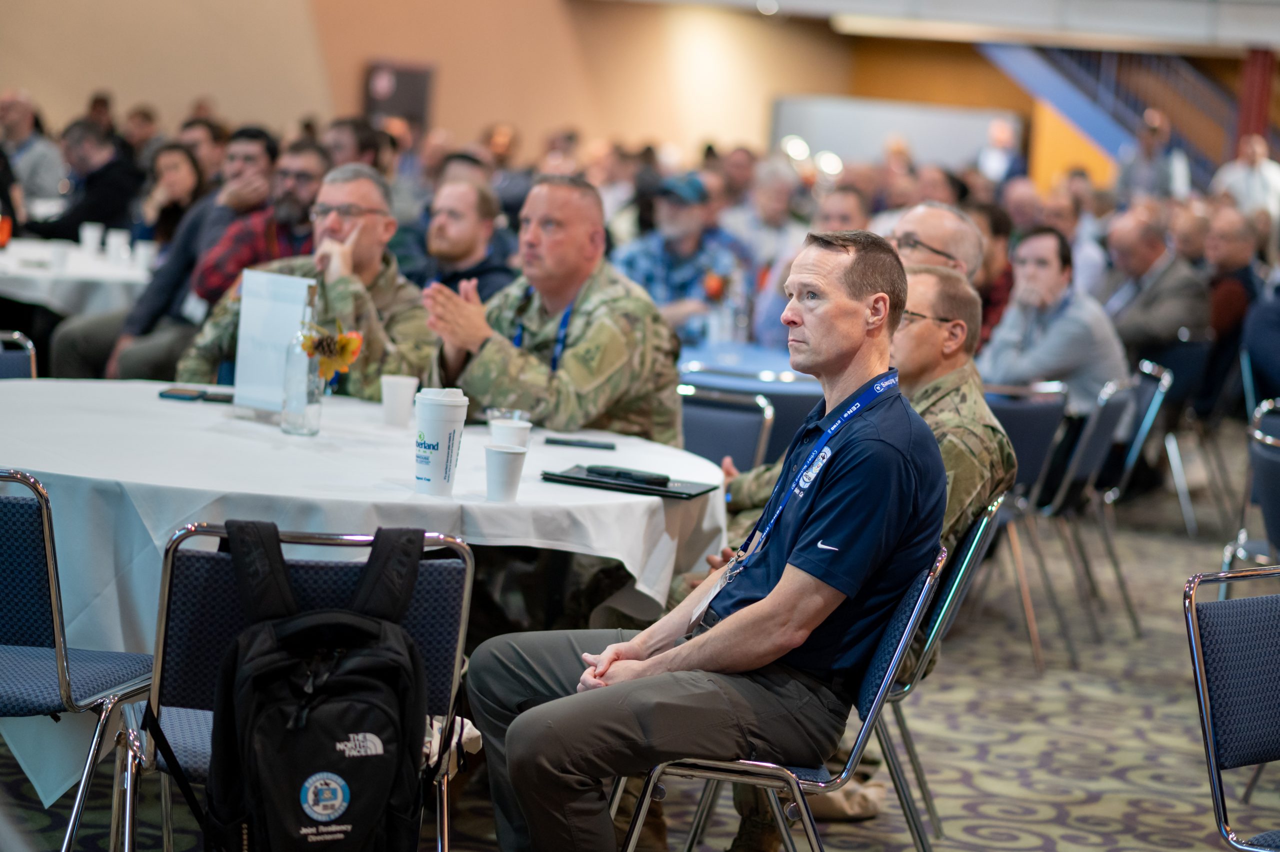 Attendees listening to a speaker on stage sitting in their chairs